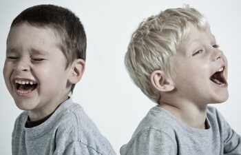 Two young boys are facing opposite directions in a photo.